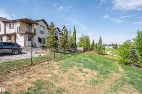 Multi-level exterior with light-colored siding and stone accents, featuring an upper-level balcony with dark railings - 40 604 62 Street, Edmonton, AB 