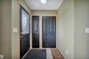 Entryway featuring a black paneled door with decorative glass insert, light-toned wall paint, and light wood trim - 40 604 62 Street, Edmonton, AB 