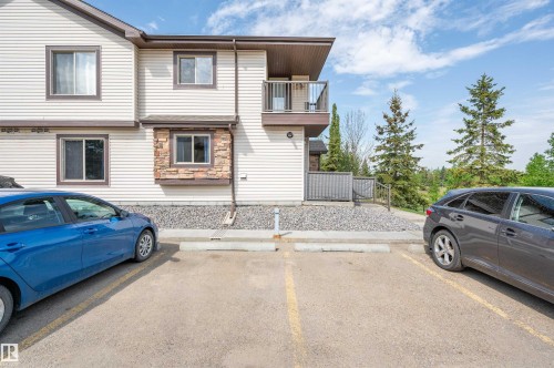 Multi-level exterior with light-colored siding, a stone accent wall, and a private balcony - 40 604 62 Street, Edmonton, AB 
