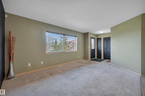 Carpeted room with a wide window featuring horizontal blinds - 40 604 62 Street, Edmonton, AB 