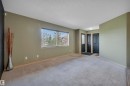 Carpeted room with a wide window featuring horizontal blinds - 40 604 62 Street, Edmonton, AB 