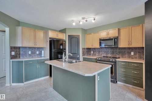 Kitchen island with integrated double basin sink and a modern faucet - 40 604 62 Street, Edmonton, AB 