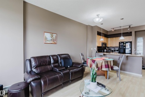 Open-concept living space featuring wood-finish flooring throughout - 1-405 4245 139 Avenue, Edmonton, AB 
