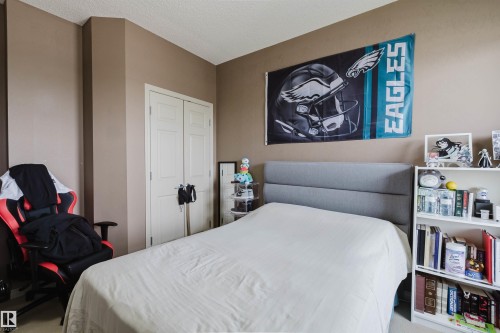 Bedroom featuring a paneled closet door and neutral wall tones - 1-405 4245 139 Avenue, Edmonton, AB 