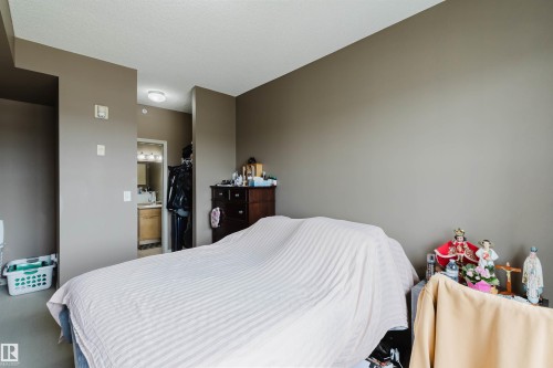 Neutral paint palette with an en-suite bathroom featuring a light wood-finish vanity and integrated lighting - 1-405 4245 139 Avenue, Edmonton, AB 