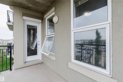 Private balcony with a concrete floor, featuring a glass-paneled door, an awning window, and a fixed window with white frames - 