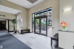 Building entrance featuring a glass double door, light-toned wall paint, recessed lighting, and a blend of light and dark tile flooring - 