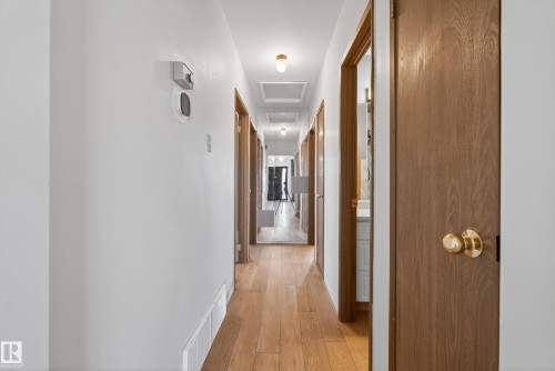 Hallway featuring wood-finish flooring, white walls, and recessed lighting - 6203 90 Avenue, Edmonton, AB 