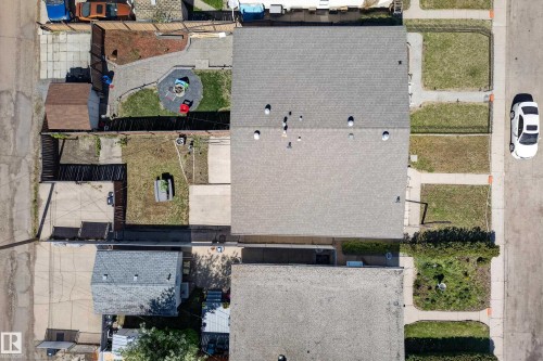 Aerial view showcasing a residential property with a shingle roof and a spacious backyard - 6203 90 Avenue, Edmonton, AB 