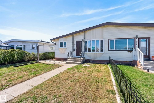 Cream-colored siding exterior featuring a multi-pane bay window and brown trim - 6203 90 Avenue, Edmonton, AB 