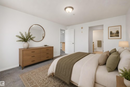 Carpeted room featuring a white interior, a semi-flush mount light fixture, and a doorway leading to an adjacent bathroom with light-toned flooring - 320 245 Edwards Drive, Edmonton, AB 
