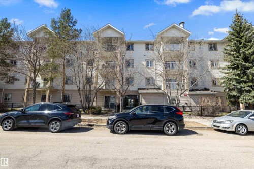 Multi-story condominium building featuring a light-colored exterior and multiple balconies - 320 245 Edwards Drive, Edmonton, AB 