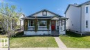 Charming bungalow exterior featuring a red entry door, covered porch with white railing, and a brick paver walkway - 29 Campbell Road, Leduc, AB 