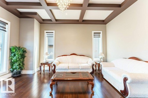 Formal living area featuring coffered ceilings with a central chandelier - 328 52327 Range Rd 233, Rural Strathcona County, AB 