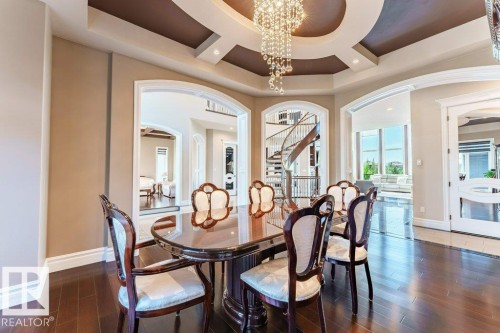 Formal dining area featuring a tray ceiling with recessed lighting and a crystal chandelier - 328 52327 Range Rd 233, Rural Strathcona County, AB 