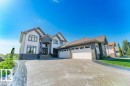 Multi-level residence featuring a stone and stucco exterior, arched windows, and a multi-car garage - 328 52327 Range Rd 233, Rural Strathcona County, AB 