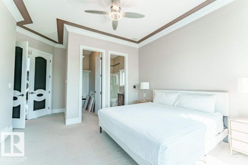 Carpeted bedroom featuring a contemporary ceiling fan, tray ceiling with contrasting trim, and crown molding - 328 52327 Range Rd 233, Rural Strathcona County, AB 