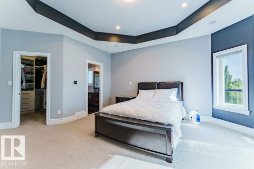 Bedroom featuring a tray ceiling with recessed lighting, light-colored carpeting, and a window - 328 52327 Range Rd 233, Rural Strathcona County, AB 