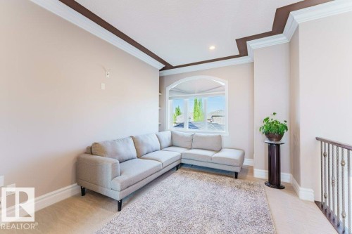 Recessed lighting and decorative ceiling trim enhance this bright space, featuring an arched window with clear glass panes - 328 52327 Range Rd 233, Rural Strathcona County, AB 