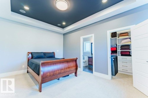 Spacious room featuring a tray ceiling with recessed lighting, light-colored walls, and neutral carpeting - 328 52327 Range Rd 233, Rural Strathcona County, AB 