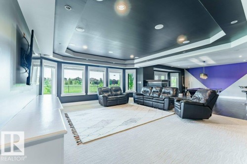 Spacious lower-level entertainment area with multiple large windows, recessed lighting, and a tray ceiling - 328 52327 Range Rd 233, Rural Strathcona County, AB 