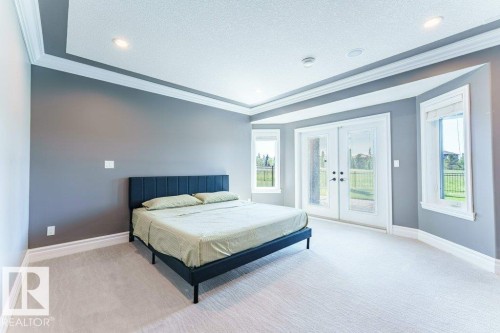 Spacious room featuring light-toned carpeting and a tray ceiling with recessed lighting - 328 52327 Range Rd 233, Rural Strathcona County, AB 