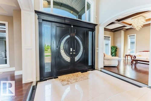 Grand double-door entry with decorative glass inserts, flanked by clear sidelights and an arched transom window - 328 52327 Range Rd 233, Rural Strathcona County, AB 