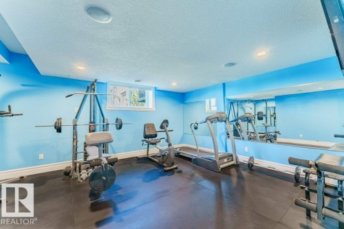 Spacious recreation room featuring recessed lighting, a window providing natural light, and a large wall-mounted mirror - 328 52327 Range Rd 233, Rural Strathcona County, AB 