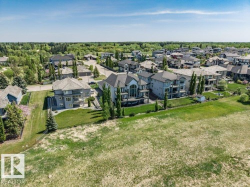 Residential neighborhood featuring a mix of multi-story homes with varied architectural styles, mature trees, and manicured lawns - 328 52327 Range Rd 233, Rural Strathcona County, AB 