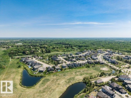 Aerial perspective showcasing a residential community surrounded by expansive natural green spaces - 328 52327 Range Rd 233, Rural Strathcona County, AB 