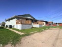Multi-unit structure featuring light green textured siding and a dark roof - 4537 50 Avenue, Cold Lake, AB 