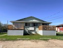 Exterior featuring two wood-railed balconies with corrugated metal skirtings - 4537 50 Avenue, Cold Lake, AB 