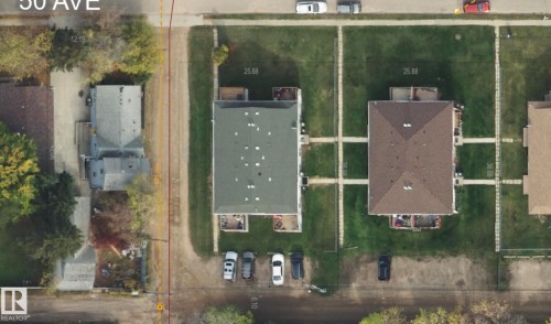 Aerial view showcasing a residential property with a brown-shingled roof, a green lawn, and distinct concrete pathways - 4537 50 Avenue, Cold Lake, AB 