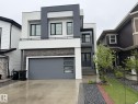 Contemporary exterior with stacked stone accents, a modern garage door with frosted windows, and a two-story design - 2123 18 Avenue, Edmonton, AB 