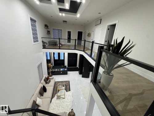 Two-story open concept living area featuring a black and glass railing system - 2123 18 Avenue, Edmonton, AB 