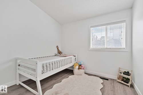 Bright room featuring a window with white blinds, light wood-finish flooring, and white baseboards - 1 Hunt Court, St. Albert, AB 