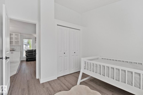 Room featuring wood-finish flooring, a white closet with bifold doors, and a neutral color palette - 1 Hunt Court, St. Albert, AB 