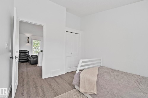Room featuring wood-finish flooring, white walls, and a bi-fold closet door - 1 Hunt Court, St. Albert, AB 