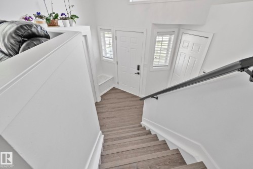 Interior staircase featuring wood-finish treads and a dark handrail - 1 Hunt Court, St. Albert, AB 