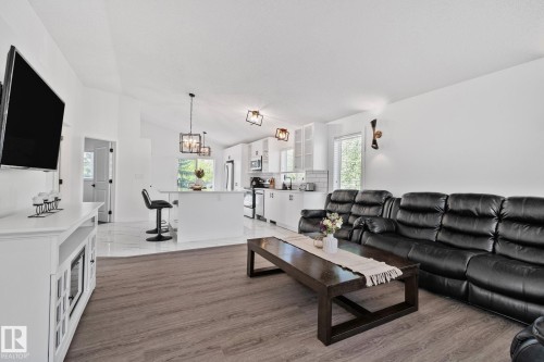 Open-concept living space featuring wood-finish flooring, vaulted ceilings, and recessed lighting - 1 Hunt Court, St. Albert, AB 