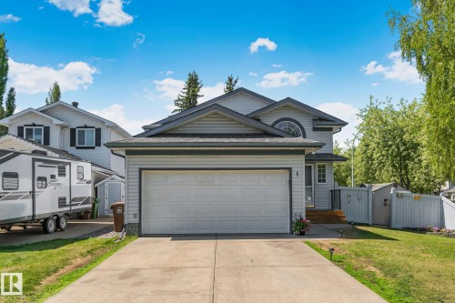 Residential property featuring light gray siding with dark trim, an attached two-car garage, and a concrete driveway - 1 Hunt Court, St. Albert, AB 