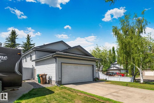 Two-story residence featuring light gray siding, a dark gray roof, and an attached single-car garage with a white door - 1 Hunt Court, St. Albert, AB 