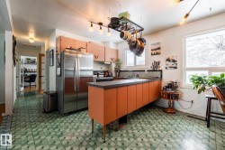 Kitchen featuring refrigerator, dark flooring, dark countertops, range with electric cooktop, and a peninsula - 