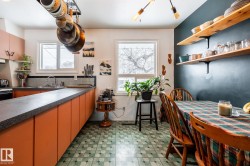 Kitchen featuring open shelves, dark countertops, light flooring, and plenty of natural light - 