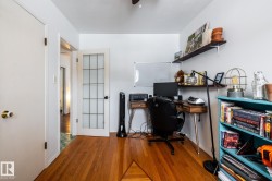 Second bedroom is also an office space, with wood floors and ceiling fan - 