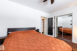 Bedroom with ceiling fan, a closet, and dark finished floors - 