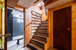 Stairway featuring wooden walls and tile patterned floors with exercise room in the background - 