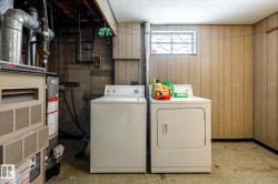 Laundry area featuring wooden walls, washer and dryer, furnace, and light flooring - 