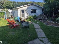 Backyard in summer featuring an outdoor fire pit, a patio area and fountain - 