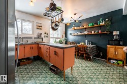 Kitchen with refrigerator, dark countertops, a peninsula, and dark floors - 